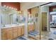 Well-lit bathroom with double sinks, mirrors, and ample cabinet space at 17637 W Browning Dr, Surprise, AZ 85374