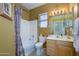 Well-lit bathroom featuring a combined shower and tub, vanity with sink, toilet, and tile flooring at 17637 W Browning Dr, Surprise, AZ 85374