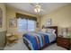 Cozy bedroom featuring a comfortable bed, a ceiling fan, and a window with bright natural light at 17637 W Browning Dr, Surprise, AZ 85374
