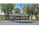 Exterior view of a community clubhouse with a covered entryway, an American flag and mature trees at 17637 W Browning Dr, Surprise, AZ 85374