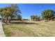Large community green area with mature trees and views of surrounding homes at 17637 W Browning Dr, Surprise, AZ 85374