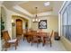 Bright dining room with tray ceiling, wood table, and natural light from a side window at 17637 W Browning Dr, Surprise, AZ 85374