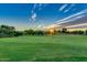 Scenic golf course view with lush green grass, mature trees, and a bright, sunny sky at sunset at 17637 W Browning Dr, Surprise, AZ 85374