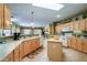 Spacious kitchen featuring oak cabinets, tile floors, and a center island at 17637 W Browning Dr, Surprise, AZ 85374