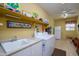 Spacious laundry room with washer, dryer, sink, and ample counter space, plus a large refrigerator at 17637 W Browning Dr, Surprise, AZ 85374
