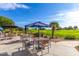 Outdoor seating area with tables and umbrellas overlooking the lush green golf course at 17637 W Browning Dr, Surprise, AZ 85374