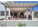 Inviting covered patio featuring a pergola, outdoor seating, a grill, and lush landscaping at 17637 W Browning Dr, Surprise, AZ 85374