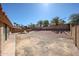 A spacious dirt backyard with a wood play structure, surrounded by block walls and palm trees at 1833 E Redfield Rd, Phoenix, AZ 85022