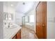 Bathroom featuring double sinks, wood cabinetry, tile countertops, neutral paint, and a shower-tub combo at 1833 E Redfield Rd, Phoenix, AZ 85022