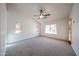 Large main bedroom featuring neutral paint, carpet flooring, a ceiling fan, and multiple windows at 1833 E Redfield Rd, Phoenix, AZ 85022