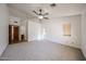 Large main bedroom featuring neutral paint, carpet flooring, a ceiling fan, and multiple windows at 1833 E Redfield Rd, Phoenix, AZ 85022