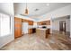 Well-lit kitchen featuring an island, wood cabinets, and tile floors with a view to the dining area at 1833 E Redfield Rd, Phoenix, AZ 85022