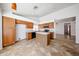 Updated kitchen featuring an island, wood cabinets, and tile floors with a view to the dining area at 1833 E Redfield Rd, Phoenix, AZ 85022