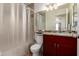 Bathroom featuring a dark wood vanity, granite countertop, and tiled shower with glass door at 1838 E Crocus Dr, Phoenix, AZ 85022