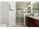 Updated bathroom featuring a tile shower with glass doors and a vanity with double sinks and granite countertops at 1838 E Crocus Dr, Phoenix, AZ 85022