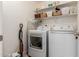 Convenient laundry room featuring a washer, dryer, shelving, and space for folding clothes at 1838 E Crocus Dr, Phoenix, AZ 85022