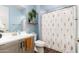 Bright bathroom features blue walls, light gray vanity, and floral shower curtain at 19181 W Jackson St, Buckeye, AZ 85326