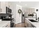 Contemporary kitchen featuring stainless steel appliances, quartz countertops, and stylish black backsplash and sink at 19181 W Jackson St, Buckeye, AZ 85326
