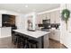 Modern kitchen with light cabinets, black hardware, quartz countertops, island with seating, and stainless steel appliances at 19181 W Jackson St, Buckeye, AZ 85326