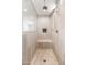 Walk-in shower features neutral tiling, built-in shelving, a shower bench, and glass enclosure at 19181 W Jackson St, Buckeye, AZ 85326