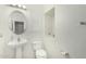 Bathroom with a pedestal sink, toilet, and white tiled walls at 1926 W Busoni Pl, Phoenix, AZ 85023