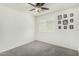 Empty bedroom with carpet, window, and ceiling fan presents a clean, inviting space at 1926 W Busoni Pl, Phoenix, AZ 85023