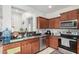 Kitchen with stainless steel appliances, tile backsplash, and dark wood cabinets at 1926 W Busoni Pl, Phoenix, AZ 85023