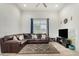 Comfortable living room with a large brown leather sectional, tile flooring, and natural light at 1926 W Busoni Pl, Phoenix, AZ 85023