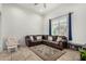 Comfortable living room with a large brown leather sectional, tile flooring, and natural light at 1926 W Busoni Pl, Phoenix, AZ 85023