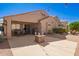 Landscaped backyard features a covered patio, fire pit, cacti, and privacy walls at 22499 N Dietz Dr, Maricopa, AZ 85138