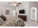 Well-lit bedroom includes a large TV and ceiling fan at 22499 N Dietz Dr, Maricopa, AZ 85138