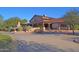A rustic style community clubhouse features stone accents, covered patio, and lush landscaping at 22499 N Dietz Dr, Maricopa, AZ 85138