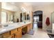 Bathroom features a double sink vanity with wood cabinets and a view of the adjacent bedroom at 2741 N 137Th Ave, Goodyear, AZ 85395