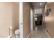 Narrow hallway with small half bath, light tan walls and neutral tile floor at 2741 N 137Th Ave, Goodyear, AZ 85395