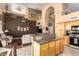 Open concept living and kitchen area with granite counters, wooden cabinets, and high ceilings at 2741 N 137Th Ave, Goodyear, AZ 85395