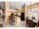 Spacious kitchen features wooden cabinets, a black refrigerator and granite countertops with breakfast bar and dining table at 2741 N 137Th Ave, Goodyear, AZ 85395