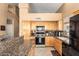 Bright kitchen featuring light wood cabinets, granite countertops, tile floors, and stainless steel appliances at 2741 N 137Th Ave, Goodyear, AZ 85395
