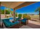 Comfortable outdoor patio with turquoise furniture, overlooking a refreshing pool and lush landscaping at 2741 N 137Th Ave, Goodyear, AZ 85395