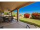 Covered patio featuring an outdoor table and chairs, offering a relaxed space with views of the well-maintained lawn at 2741 N 137Th Ave, Goodyear, AZ 85395