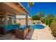 Inviting pool area with lounge seating, a well-manicured lawn, and vibrant landscaping under a clear blue sky at 2741 N 137Th Ave, Goodyear, AZ 85395