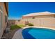 Beautiful pool with a pebble-covered deck and a backdrop of lush green landscaping against a blue sky at 2741 N 137Th Ave, Goodyear, AZ 85395