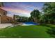 Expansive backyard with lush artificial grass, a sparkling pool, and cozy lounge area, perfect for outdoor entertaining at 3535 E Crescent Way, Gilbert, AZ 85298
