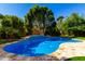 Backyard pool surrounded by lush greenery and stone features creates a serene oasis for relaxation and recreation at 3535 E Crescent Way, Gilbert, AZ 85298