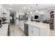 Open kitchen with large marble island features stainless steel appliances and modern white cabinets at 3535 E Crescent Way, Gilbert, AZ 85298