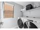 Convenient laundry room with modern washer, dryer, and shelving for supplies at 3535 E Crescent Way, Gilbert, AZ 85298
