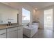 Bright bathroom with dual vanities, a standalone tub, and a large window offering natural light and views at 35703 N Geode Way, San Tan Valley, AZ 85144