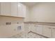 Bright laundry room featuring star pattern floors, storage and utility sink at 35703 N Geode Way, San Tan Valley, AZ 85144