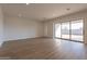 Bright living room featuring wood-look flooring, natural light from the slider to the backyard and neutral paint at 35703 N Geode Way, San Tan Valley, AZ 85144