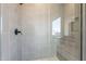 Modern shower featuring gray tile, a rainfall showerhead, and a glass partition showcasing sleek design at 35703 N Geode Way, San Tan Valley, AZ 85144