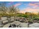 Desert home backyard with a stone waterfall feature, surrounded by desert landscaping and cozy seating with mountain views at 37170 N Greythorn Cir, Carefree, AZ 85377